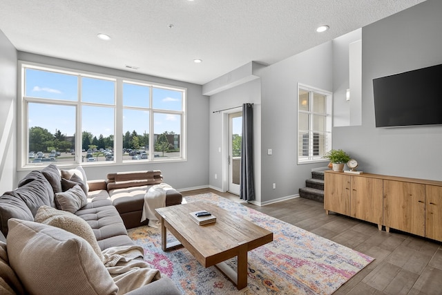 640 S 50th St Unit 2204, West Des Moines, IA 50265 - living room with light wood-style flooring, stairway, recessed lighting, and a textured ceiling