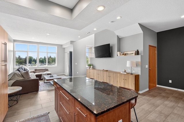 640 S 50th St Unit 2204, West Des Moines, IA 50265 - kitchen featuring a kitchen bar, open floor plan, plenty of natural light, dark stone countertops, and recessed lighting