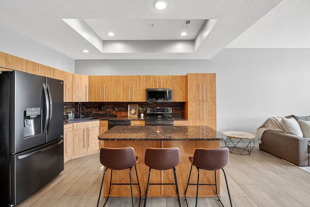 640 S 50th St Unit 2204, West Des Moines, IA 50265 - kitchen with appliances with stainless steel finishes, a breakfast bar, a center island, light wood finished floors, and recessed lighting