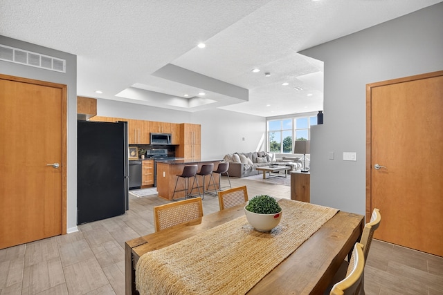 640 S 50th St Unit 2204, West Des Moines, IA 50265 - dining room featuring light wood finished floors, recessed lighting, a tray ceiling, and a textured ceiling