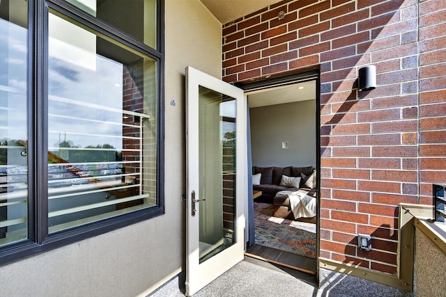 640 S 50th St Unit 2204, West Des Moines, IA 50265 - view of exterior entry with brick siding, a balcony, and stucco siding