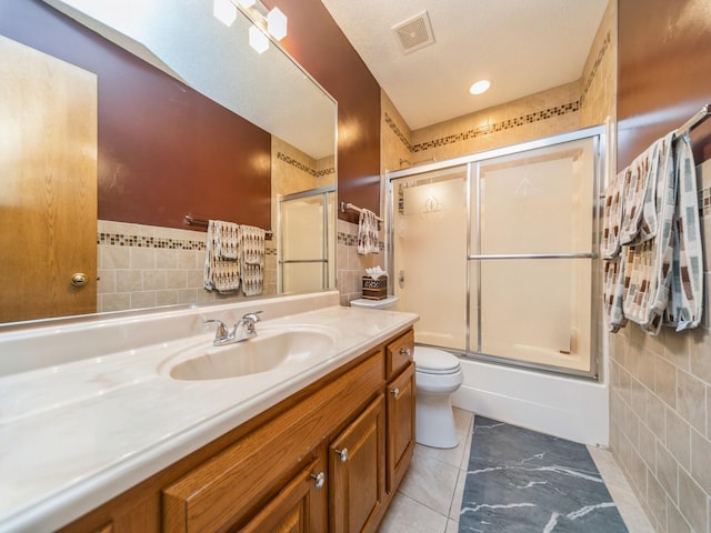3436 Valley View Dr, West Des Moines, IA 50265 - full bathroom featuring tile walls, vanity, and shower / bath combination with glass door