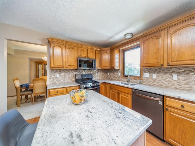 3436 Valley View Dr, West Des Moines, IA 50265 - kitchen featuring appliances with stainless steel finishes, decorative backsplash, brown cabinetry, and a textured ceiling