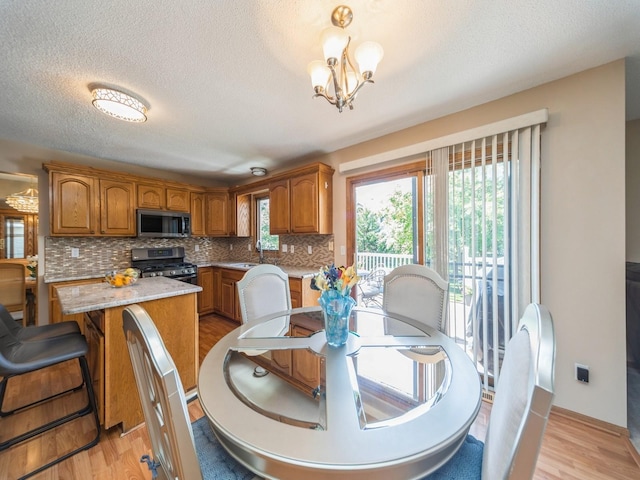 3436 Valley View Dr, West Des Moines, IA 50265 - dining space with a chandelier, healthy amount of natural light, light wood-style flooring, and a textured ceiling