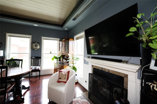 344 S 1st St, Ogden, IA 50212 - living room with a tiled fireplace, dark wood-style floors, wooden ceiling, ornamental molding, and a tray ceiling