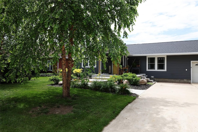 344 S 1st St, Ogden, IA 50212 - view of front of house with a front yard, driveway, roof with shingles, and a garage