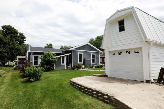 344 S 1st St, Ogden, IA 50212 - view of front of property with a front yard, a metal roof, a gambrel roof, and driveway