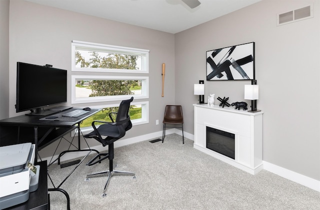 9138 Moonseed Ct, West Des Moines, IA 50266 - home office featuring carpet flooring, a glass covered fireplace, and ceiling fan