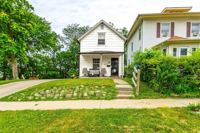 1054 14th St, Des Moines, IA 50314 - view of front of property with a porch, a front lawn, and cooling unit