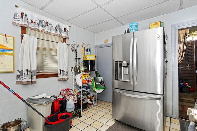 1054 14th St, Des Moines, IA 50314 - kitchen with stainless steel refrigerator with ice dispenser, a drop ceiling, and light tile patterned flooring