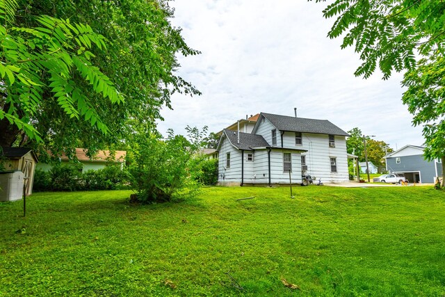 1054 14th St, Des Moines, IA 50314 - view of grassy yard with a storage shed