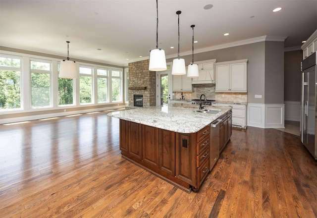 4701 150th St, Urbandale, IA 50323 - kitchen featuring dark wood-type flooring, ornamental molding, white cabinetry, a large fireplace, and light stone countertops