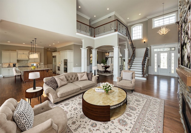 4701 150th St, Urbandale, IA 50323 - living area featuring ornate columns, a towering ceiling, dark wood-type flooring, stairway, and recessed lighting