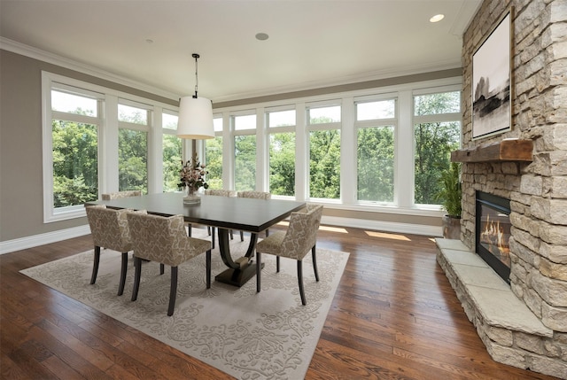 4701 150th St, Urbandale, IA 50323 - dining room with ornamental molding, healthy amount of natural light, a fireplace, and dark wood-type flooring