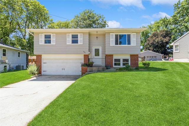 311 W 15th St N, Newton, IA 50208 - raised ranch featuring brick siding, a garage, a front lawn, and concrete driveway