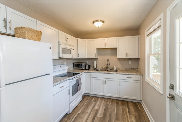 311 W 15th St N, Newton, IA 50208 - kitchen featuring white appliances, wood finished floors, and white cabinets