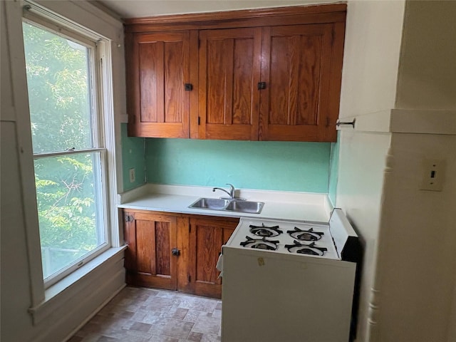 3101 Cottage Grove Ave, Des Moines, IA 50311 - kitchen featuring brown cabinetry, white range with gas cooktop, and light countertops