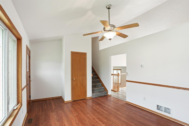 2907 E 43rd St, Des Moines, IA 50317 - unfurnished room with wood finished floors, ceiling fan, plenty of natural light, lofted ceiling, and stairs