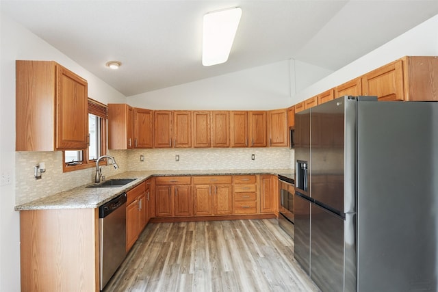 2907 E 43rd St, Des Moines, IA 50317 - kitchen featuring stainless steel appliances, vaulted ceiling, light wood-style floors, light stone countertops, and decorative backsplash