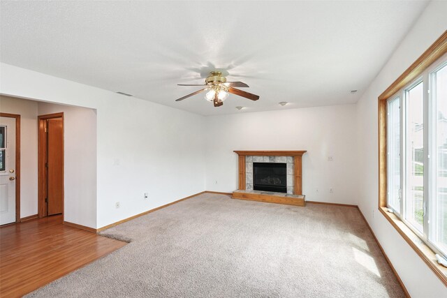 2907 E 43rd St, Des Moines, IA 50317 - unfurnished living room featuring carpet floors, a ceiling fan, and a tile fireplace