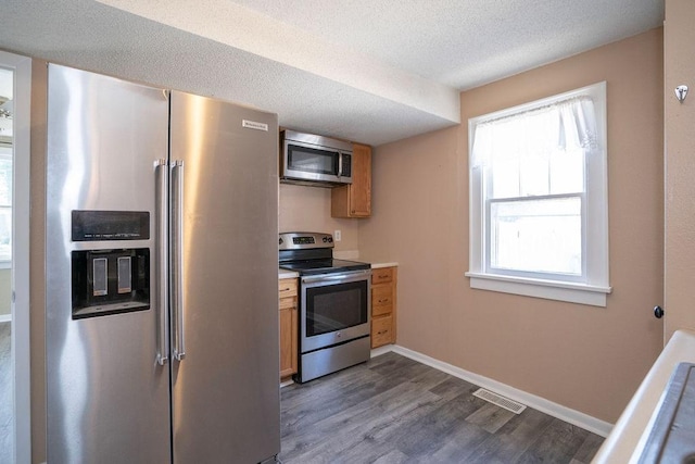 1421 N 4th Ave E, Newton, IA 50208 - kitchen with stainless steel appliances, dark wood-style floors, light countertops, and a textured ceiling