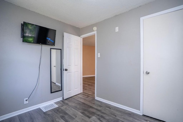 1421 N 4th Ave E, Newton, IA 50208 - unfurnished bedroom with wood finished floors and a textured ceiling