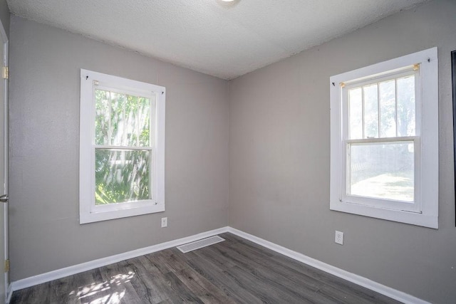 1421 N 4th Ave E, Newton, IA 50208 - spare room featuring dark wood-type flooring and a textured ceiling