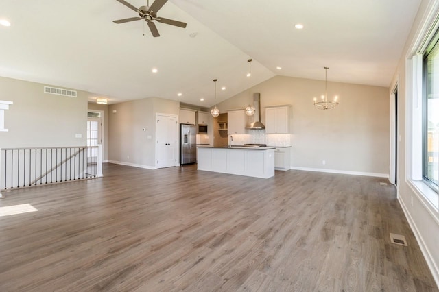 1809 12th St SE, Altoona, IA 50009 - unfurnished living room featuring a ceiling fan, a chandelier, high vaulted ceiling, wood finished floors, and recessed lighting