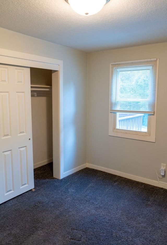 1600 Evergreen Ave, Des Moines, IA 50320 - unfurnished bedroom with dark colored carpet, a closet, and a textured ceiling