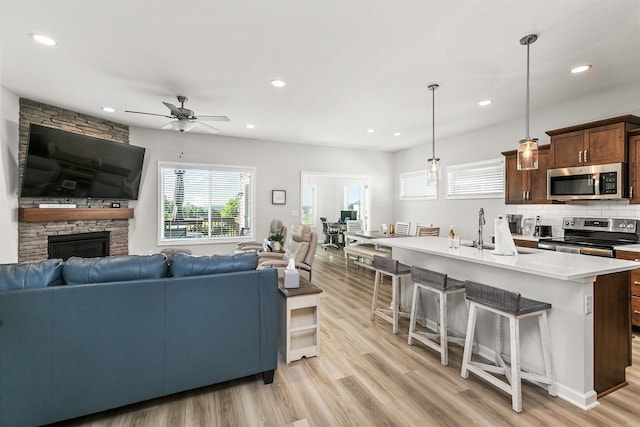 8932 Mockingbird Dr, West Des Moines, IA 50266 - living area featuring light wood finished floors, a ceiling fan, recessed lighting, and a fireplace