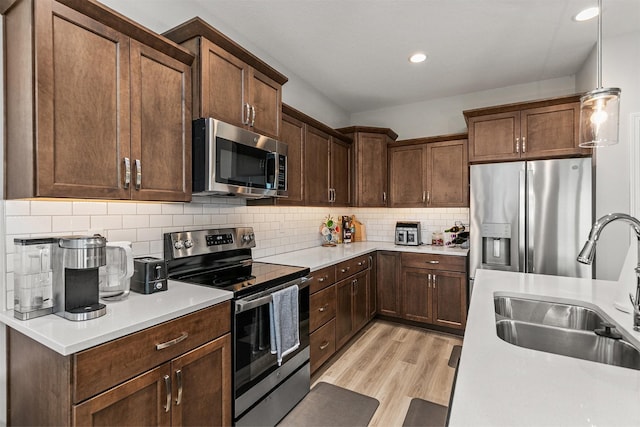 8932 Mockingbird Dr, West Des Moines, IA 50266 - kitchen with stainless steel appliances, light wood-style floors, light countertops, decorative backsplash, and recessed lighting