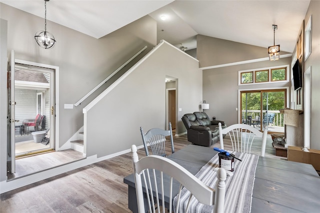 1123 SE Mallard Creek Dr, Ankeny, IA 50021 - dining room with high vaulted ceiling, stairway, a chandelier, and wood finished floors