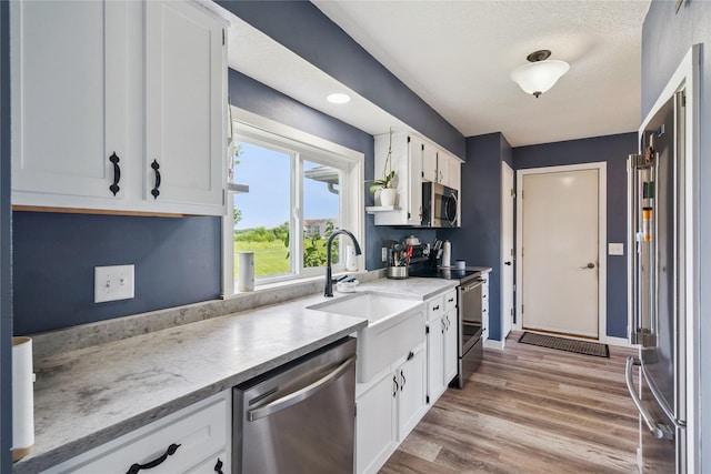 1123 SE Mallard Creek Dr, Ankeny, IA 50021 - kitchen with appliances with stainless steel finishes, white cabinets, light countertops, and light wood-style floors