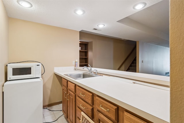 1123 SE Mallard Creek Dr, Ankeny, IA 50021 - kitchen with white microwave, brown cabinets, light countertops, light tile patterned floors, and recessed lighting