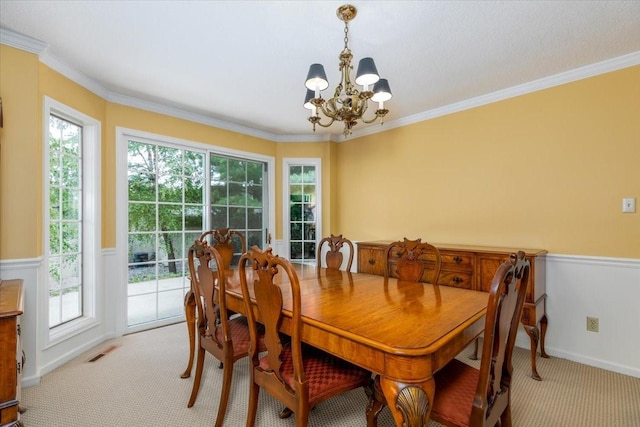 7819 Luin Ln, Windsor Heights, IA 50324 - dining space with a chandelier, carpet flooring, crown molding, and wainscoting