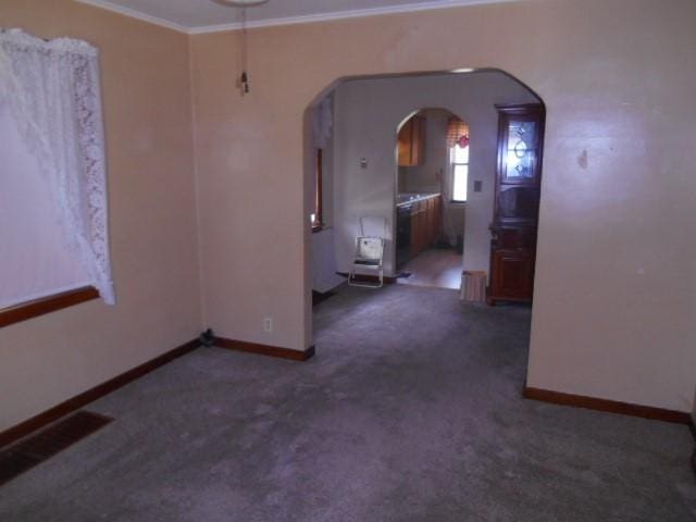 702 Woodbury St, Marshalltown, IA 50158 - carpeted empty room featuring arched walkways and ornamental molding