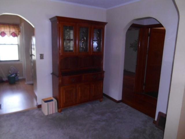 702 Woodbury St, Marshalltown, IA 50158 - hall featuring arched walkways, crown molding, and carpet