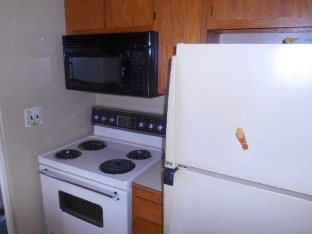 702 Woodbury St, Marshalltown, IA 50158 - kitchen featuring white appliances and brown cabinets