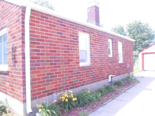702 Woodbury St, Marshalltown, IA 50158 - view of property exterior with brick siding and an outbuilding