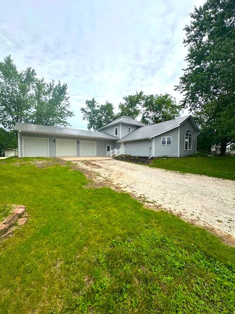 426 N 1st St, Ogden, IA 50212 - tri-level home featuring dirt driveway, a front yard, and a garage