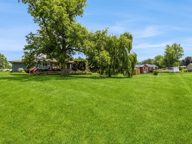 470 Juniper Ave, Kellogg, IA 50135 - view of grassy yard featuring a deck
