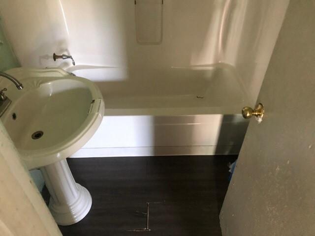 920 Amos Ave, Des Moines, IA 50315 - full bathroom featuring tub / shower combination and wood finished floors