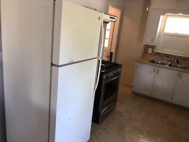 920 Amos Ave, Des Moines, IA 50315 - kitchen featuring freestanding refrigerator, stainless steel gas range, and light flooring
