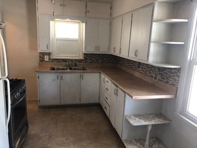 920 Amos Ave, Des Moines, IA 50315 - kitchen featuring open shelves, black gas stove, tasteful backsplash, and healthy amount of natural light