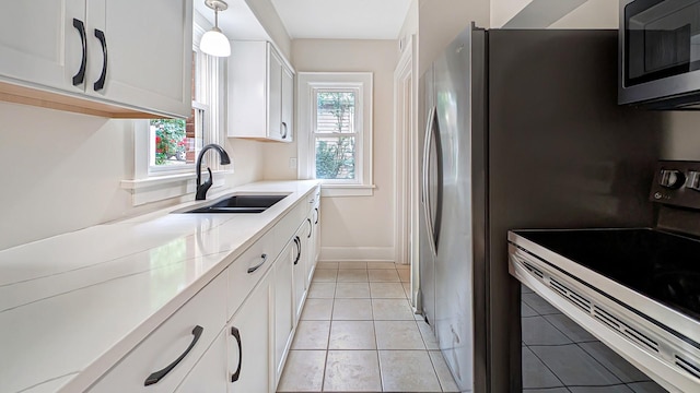 343 58th St, Des Moines, IA 50312 - kitchen featuring stainless steel microwave, electric range oven, white cabinetry, light countertops, and light tile patterned flooring