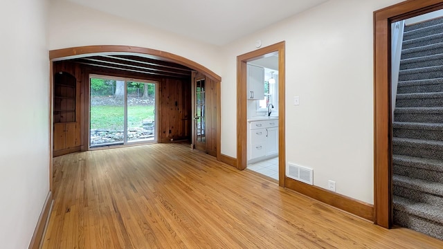 343 58th St, Des Moines, IA 50312 - empty room featuring light wood-style floors, stairs, and arched walkways