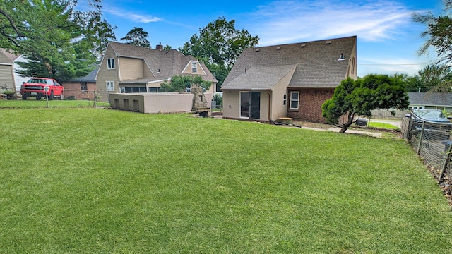 343 58th St, Des Moines, IA 50312 - back of property featuring roof with shingles and brick siding