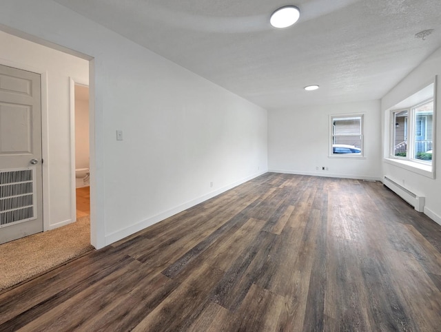1410 Thomas St, Redfield, IA 50233 - unfurnished room featuring baseboard heating and dark wood-type flooring