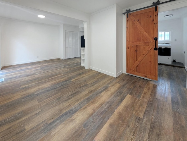 1410 Thomas St, Redfield, IA 50233 - unfurnished room featuring wood finished floors, a barn door, and washer / clothes dryer