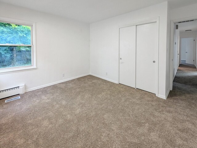 1410 Thomas St, Redfield, IA 50233 - unfurnished bedroom with carpet, a closet, and baseboard heating